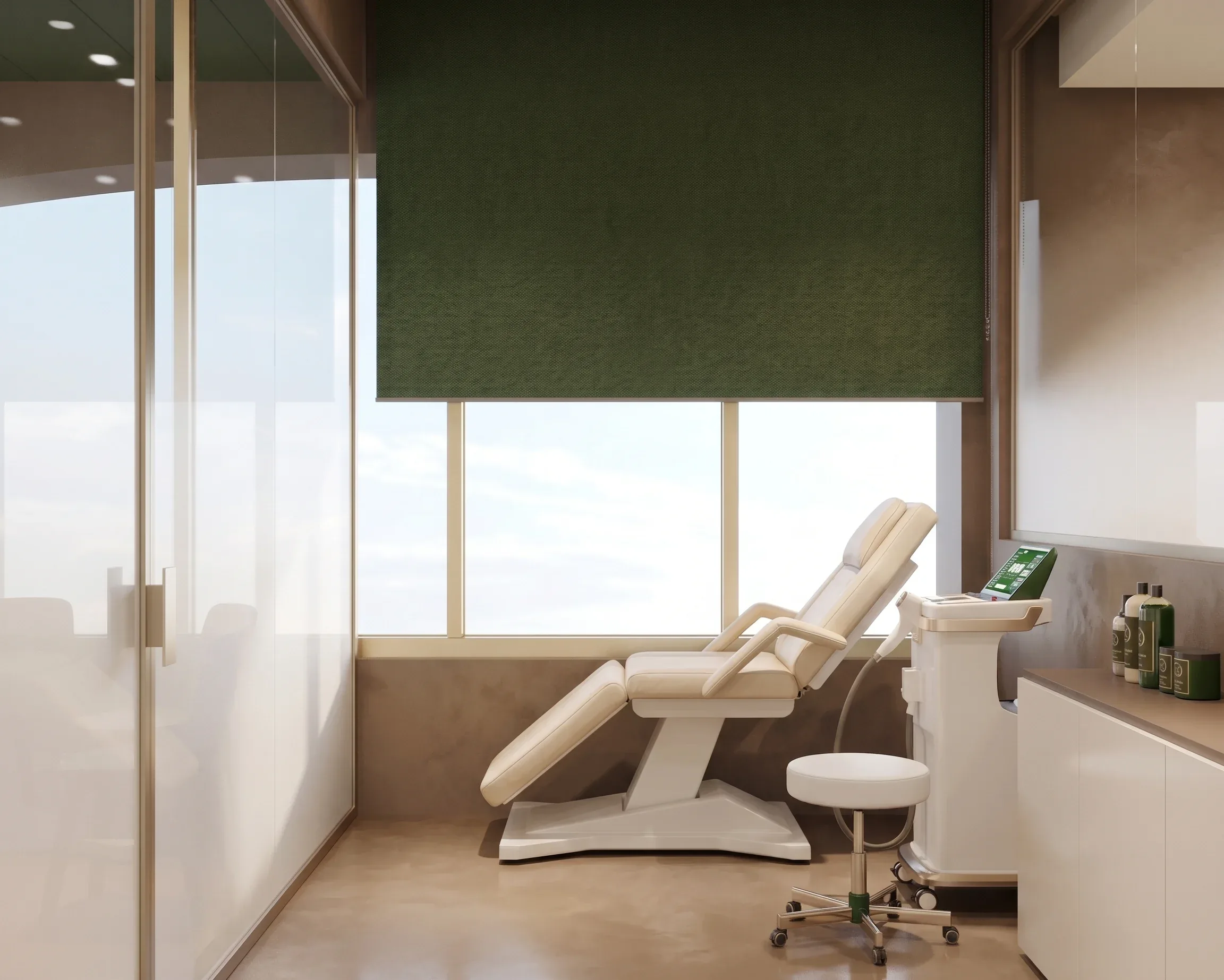 Treatment room with a white reclining chair, laser equipment and a window behind a dark green blind, Aqua Beauty Clinic
