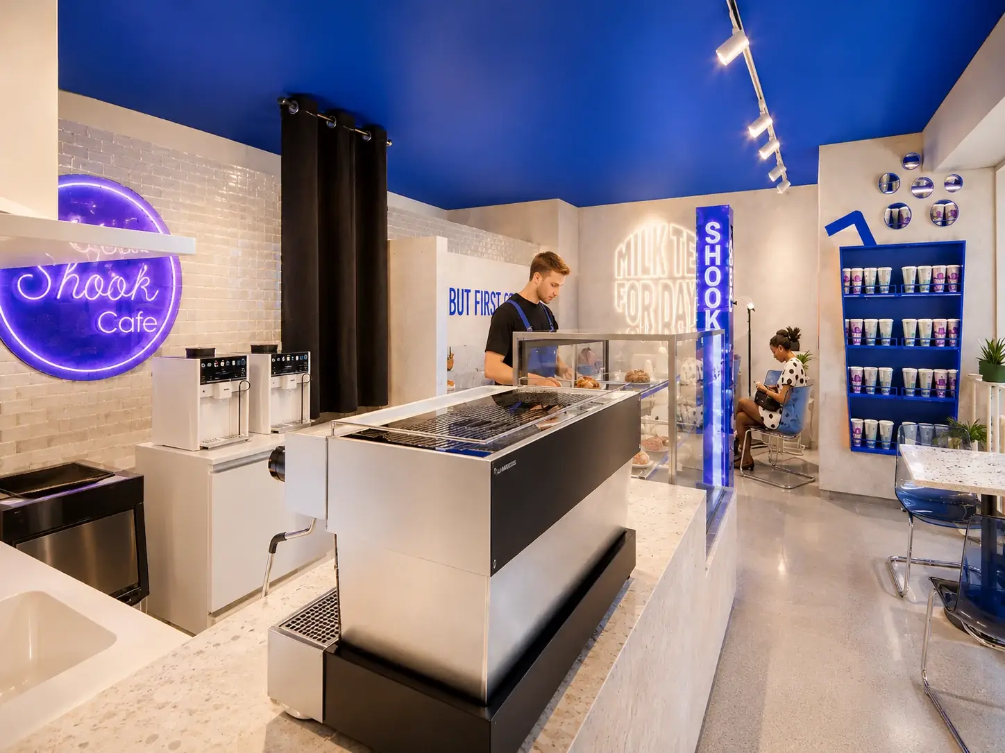 Shook Cafe in Waterloo: a blue ceiling, the neon logo, a white coffee counter and a lit blue column